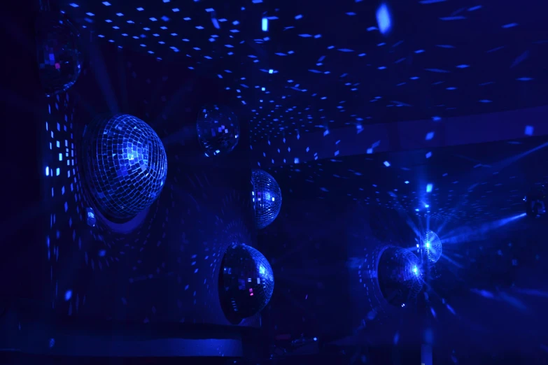 many disco balls in the air with blue lights