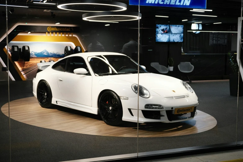 a white sports car sitting inside of a room