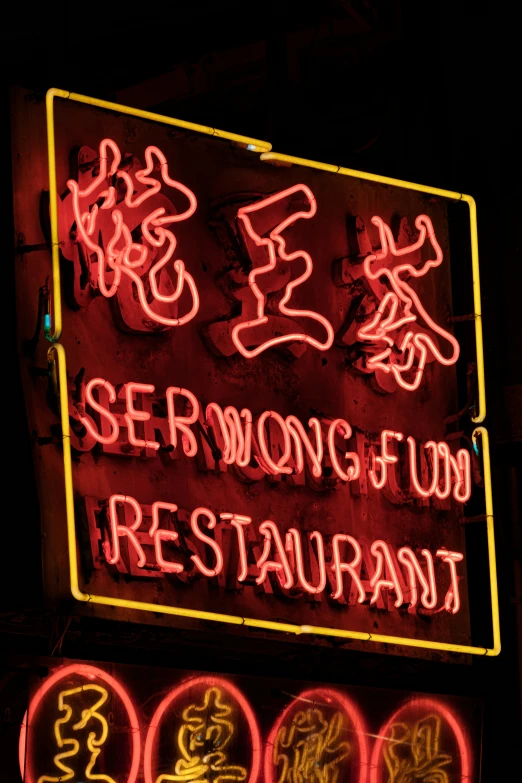 an asian neon sign is shown in dark