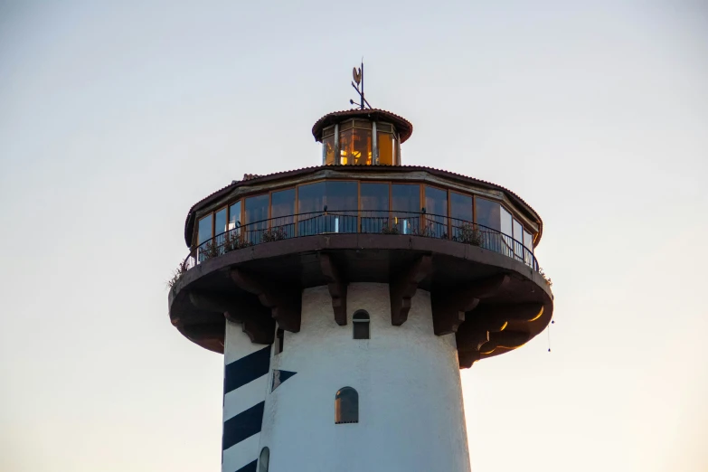 a white and black light house and some clouds