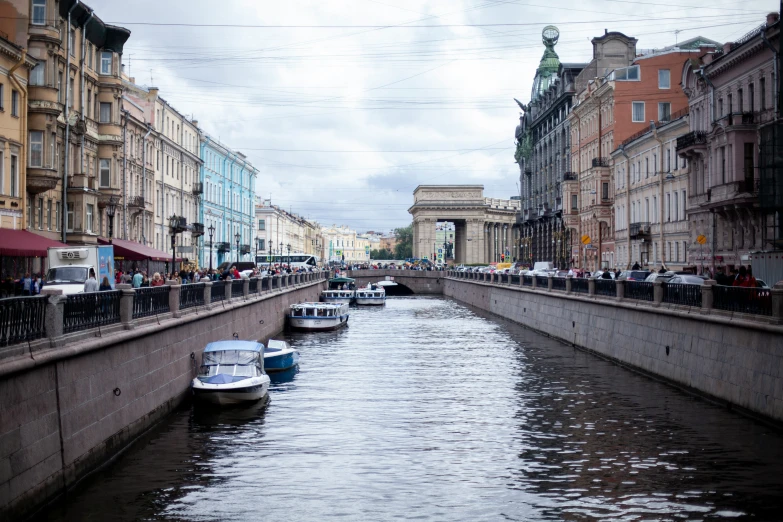 the narrow waterway in a city has several boats