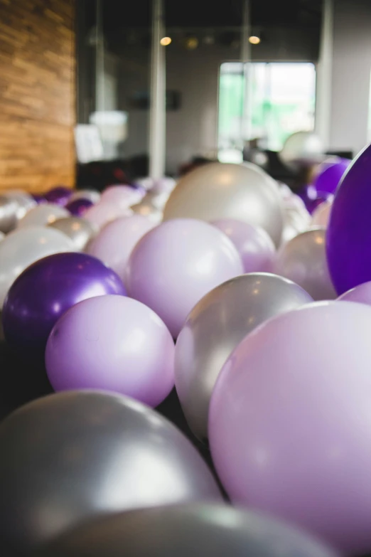 a table filled with lots of balloons with one balloon flying in the air