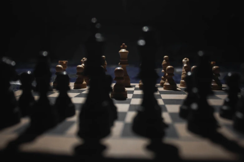 black and white chess pieces in the dark