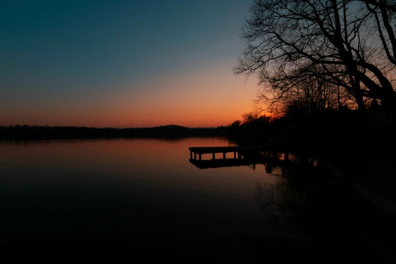 the sun is setting over the water next to the shore