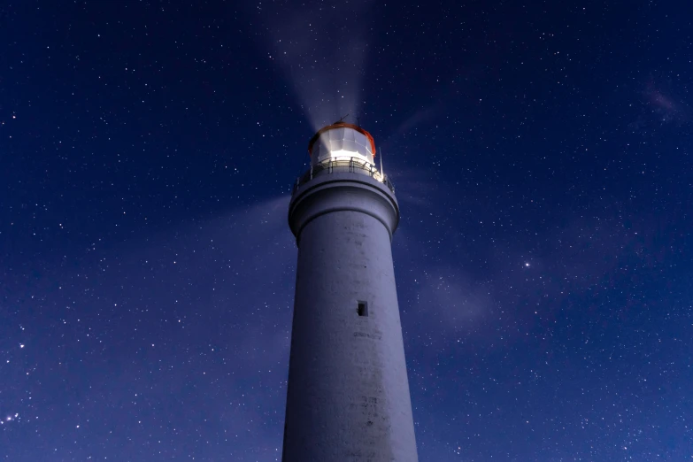 a lighthouse on a clear night with lots of stars