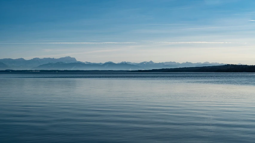 a boat is traveling in the water with mountains in the distance