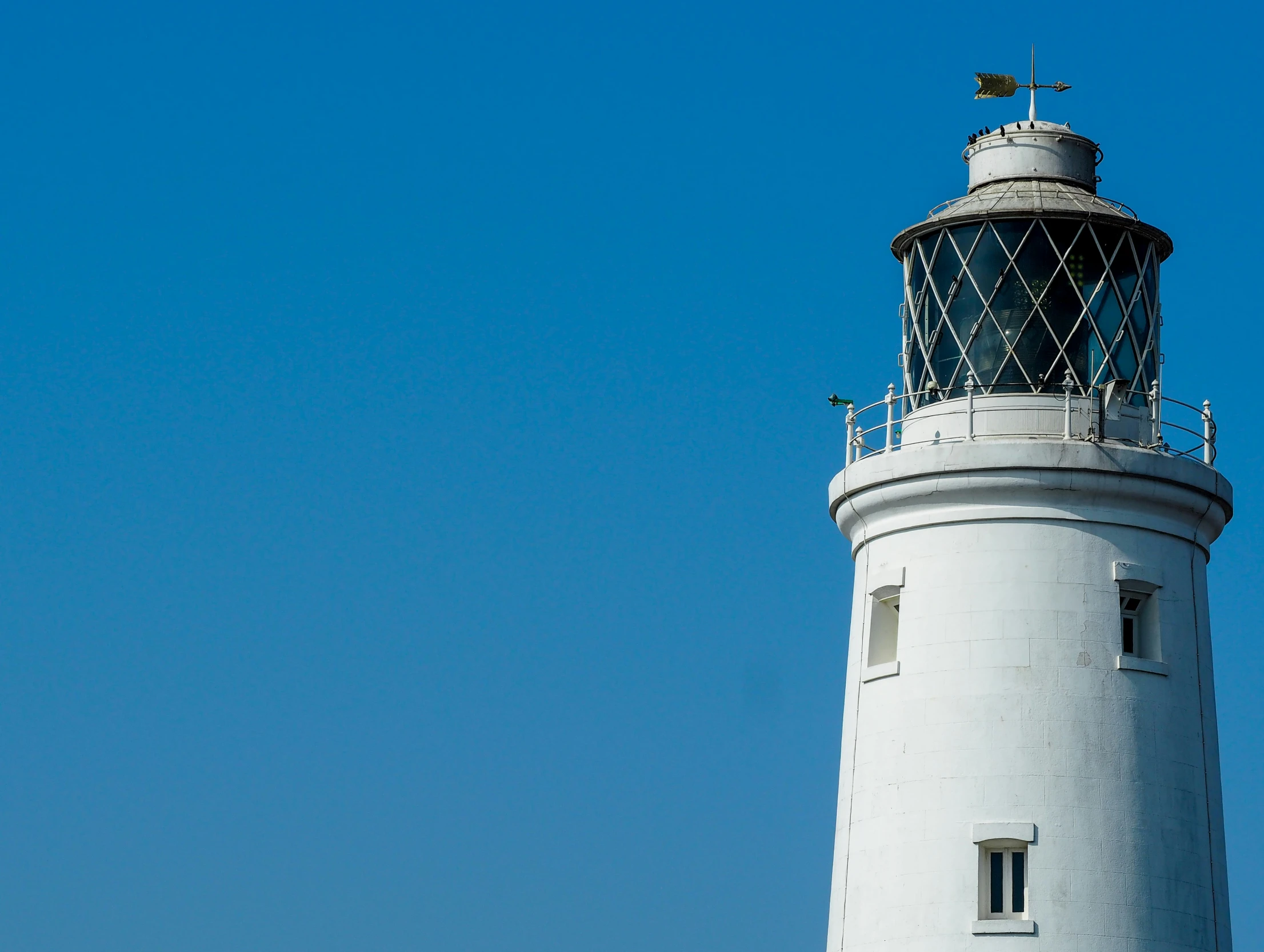 a large white lighthouse with a cross on top