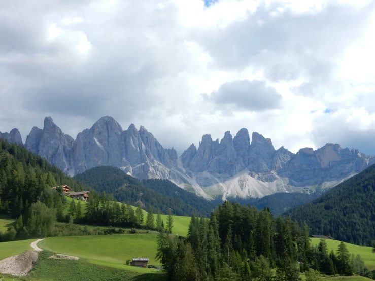 a green valley covered with mountains in the background