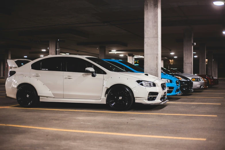 many white cars parked in a parking garage