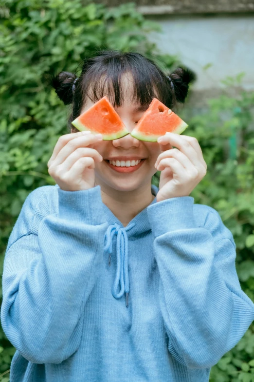 the girl has one slice of watermelon in her face