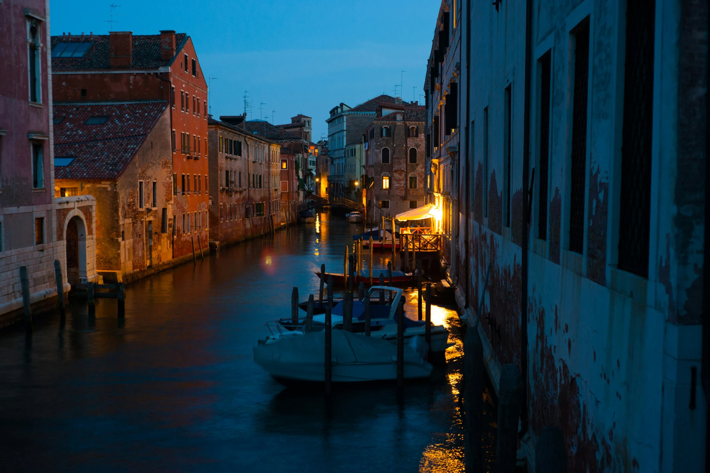 an alley with lots of buildings and boats in the middle