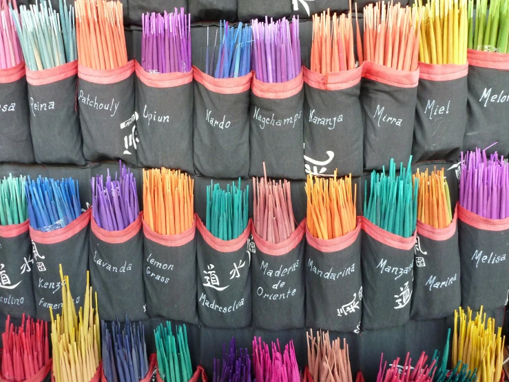 a large display of colored matchsticks next to a black wall