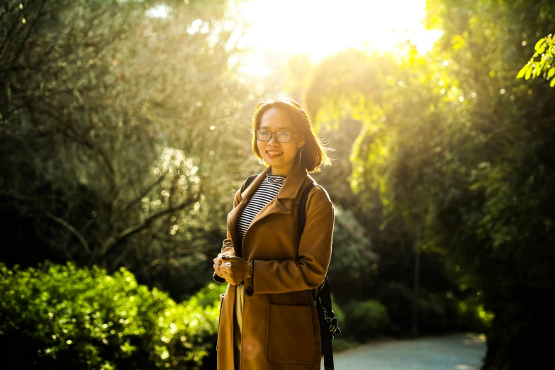 the woman smiles at the camera outside on a sunny day