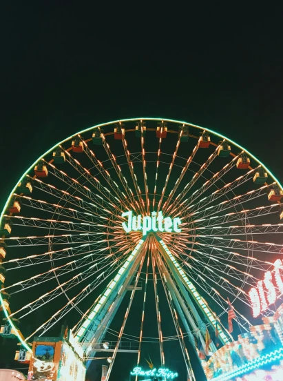 a large wheel is lit up at night