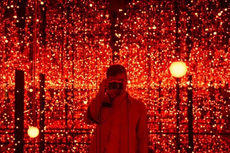 a man is in front of a red background with lights