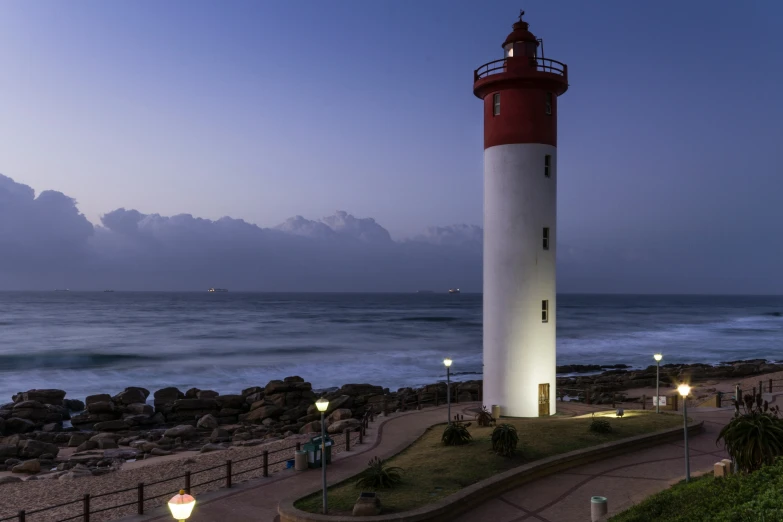 a lighthouse near the ocean on a clear evening