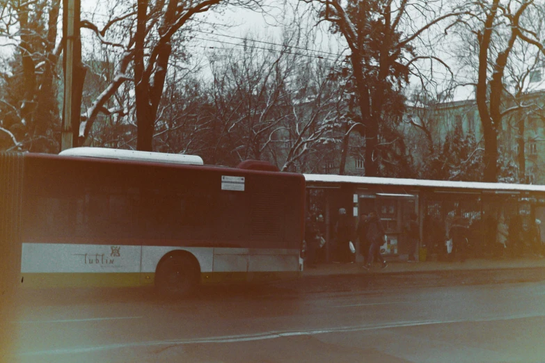 an empty bus parked on the street next to the trees