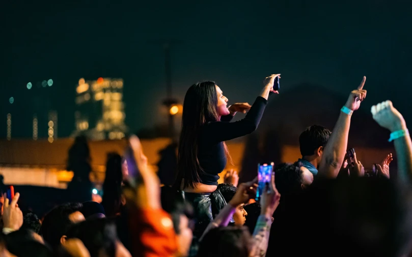 a group of people at a concert with their hands up