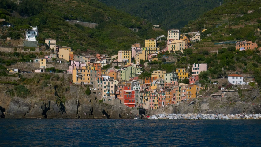 the colorful buildings are on the rocky side by the water