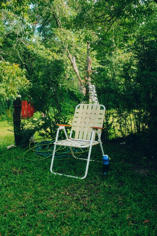 white lawn chair with wheels parked under the trees