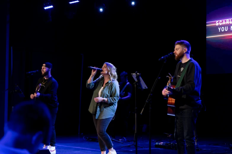 an image of group of people singing on stage