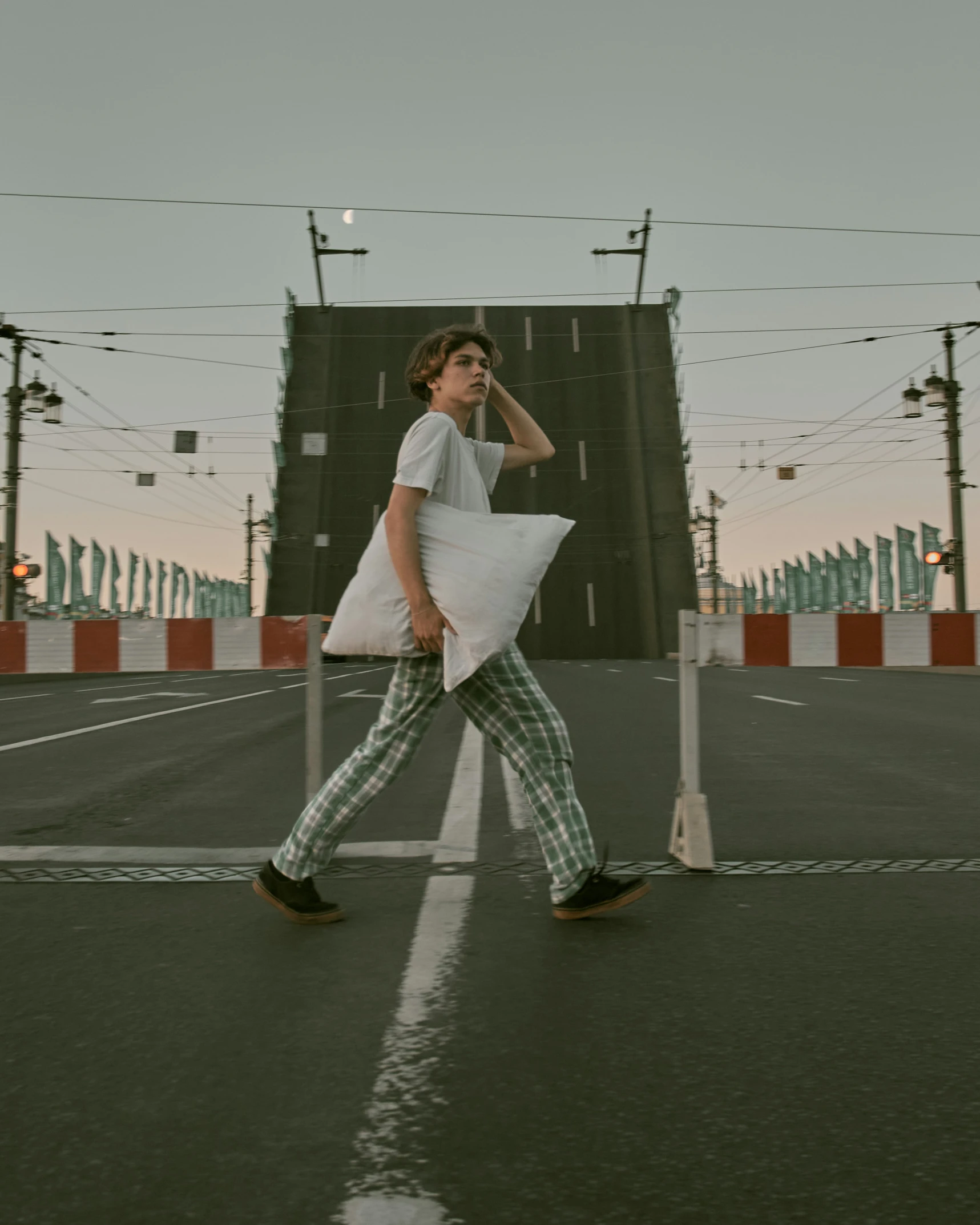 a young man crossing the street with his back to the camera