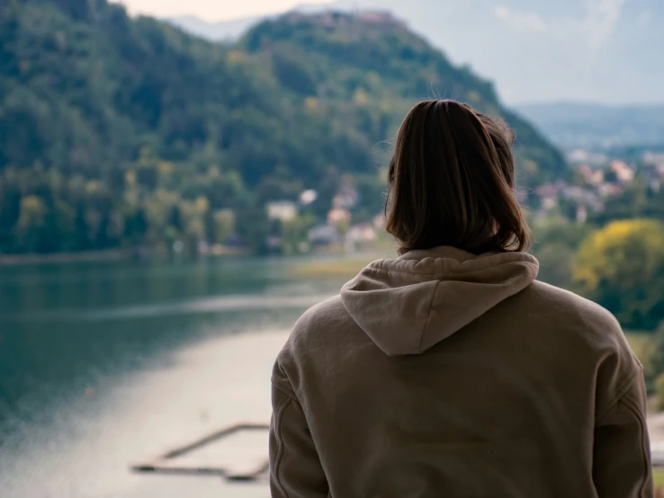 person looking out to the river and city from behind