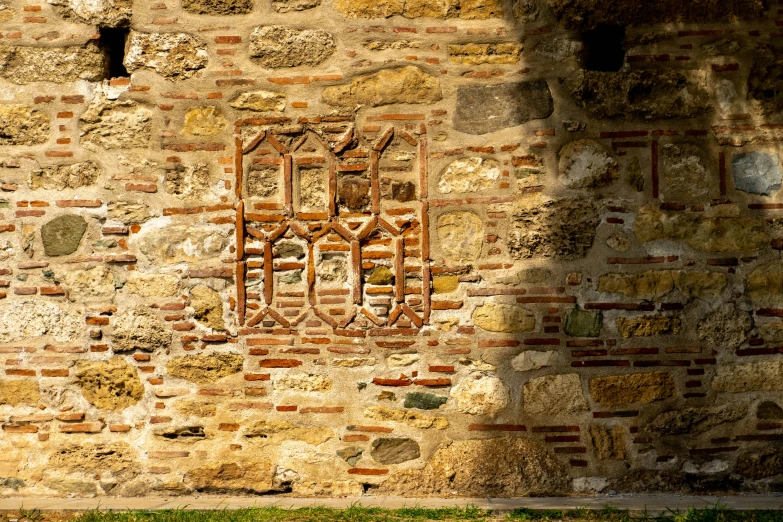 an ancient brick wall with a window cut in the center