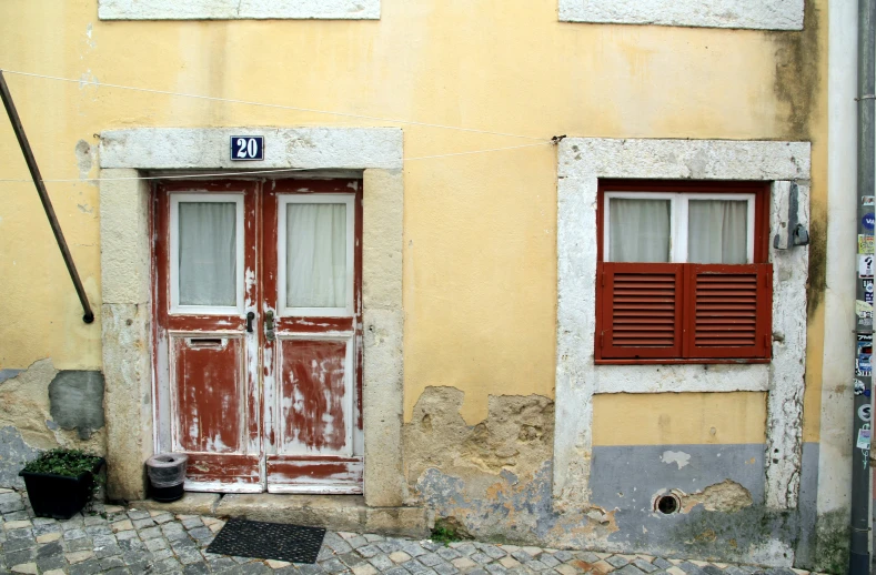 two red doors and some windows with a pole