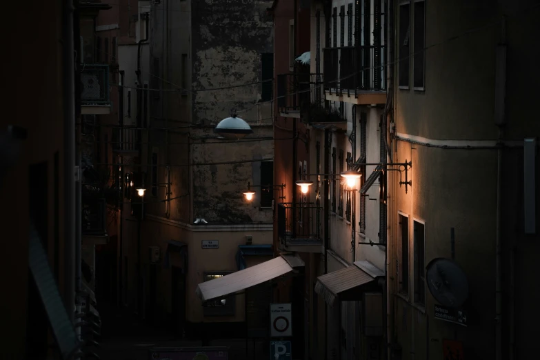 view down the narrow streets of a town with light on