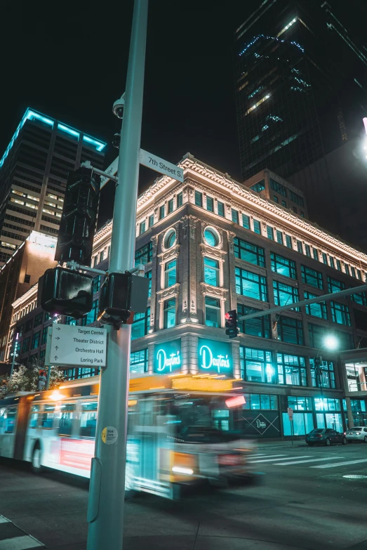 blurry bus lights on the corner of a street at night