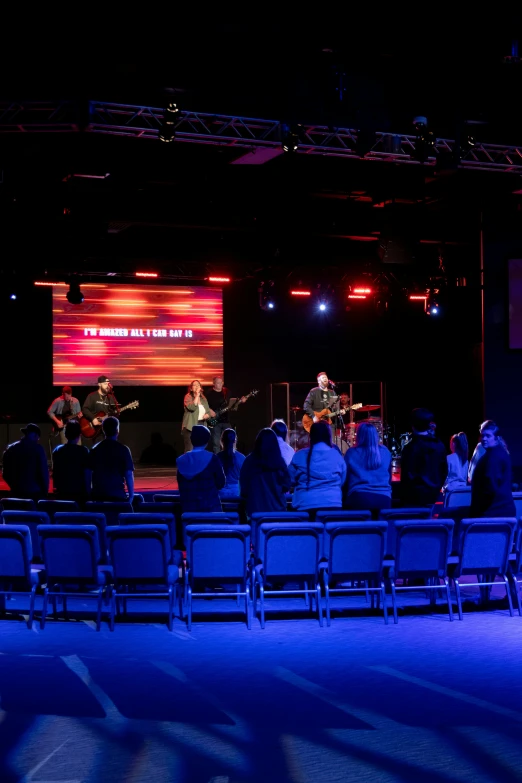 a band is performing on stage in an auditorium