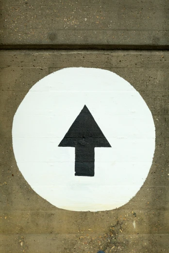 a white and black directional sign on the side of a road