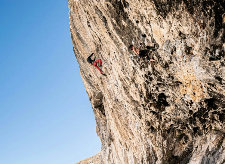 the climbers are climbing up the rocky mountain