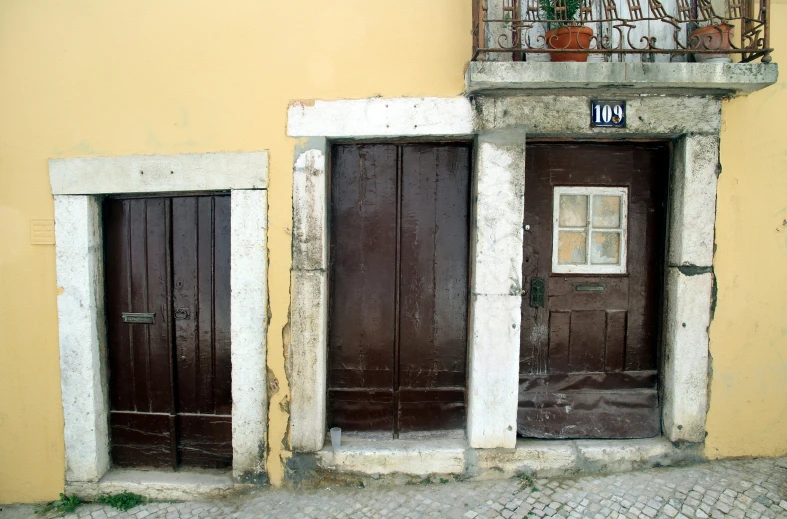 two brown doors sitting on the side of a building