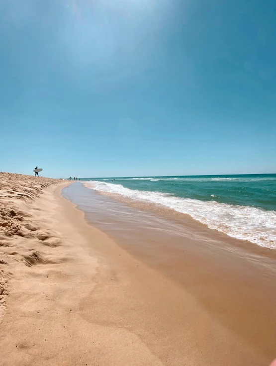 a long sand beach lined with footprints and clear water