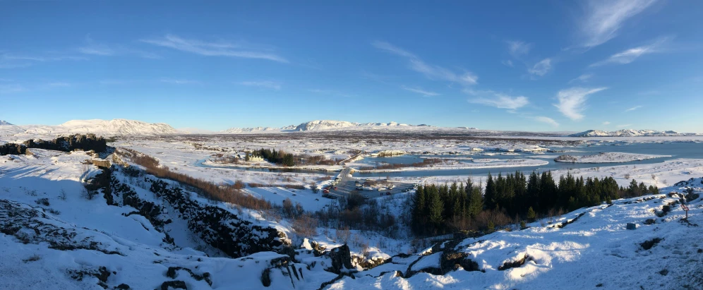 view of mountains, snow, and the ocean from above