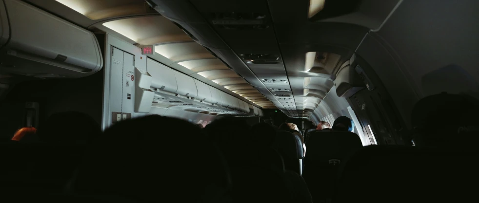 the interior of an airplane with people on seats and one plane has lots of space