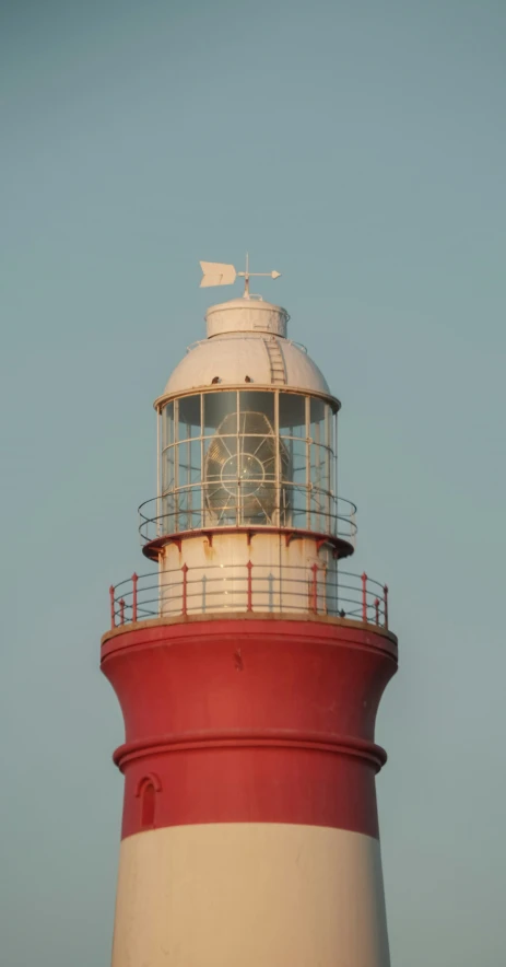 a red and white lighthouse with a clock