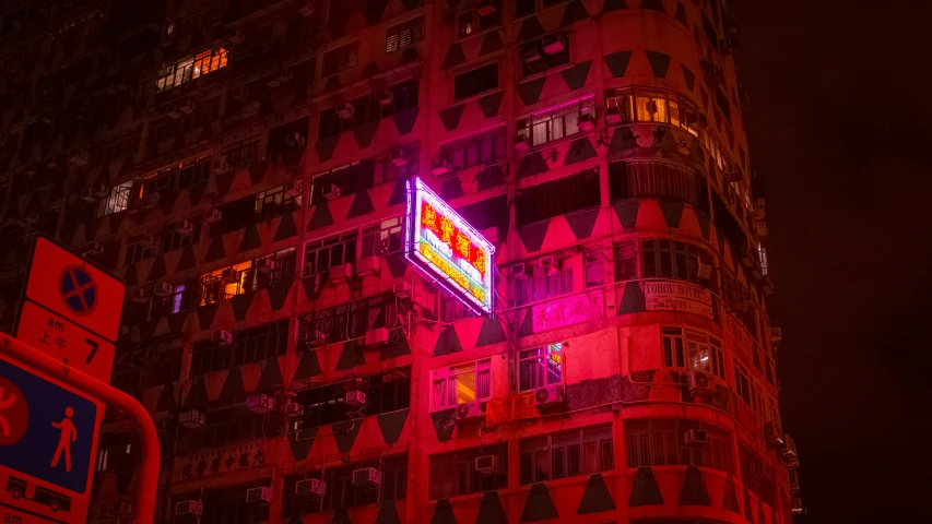 the buildings lit up red and white with a neon sign in the middle