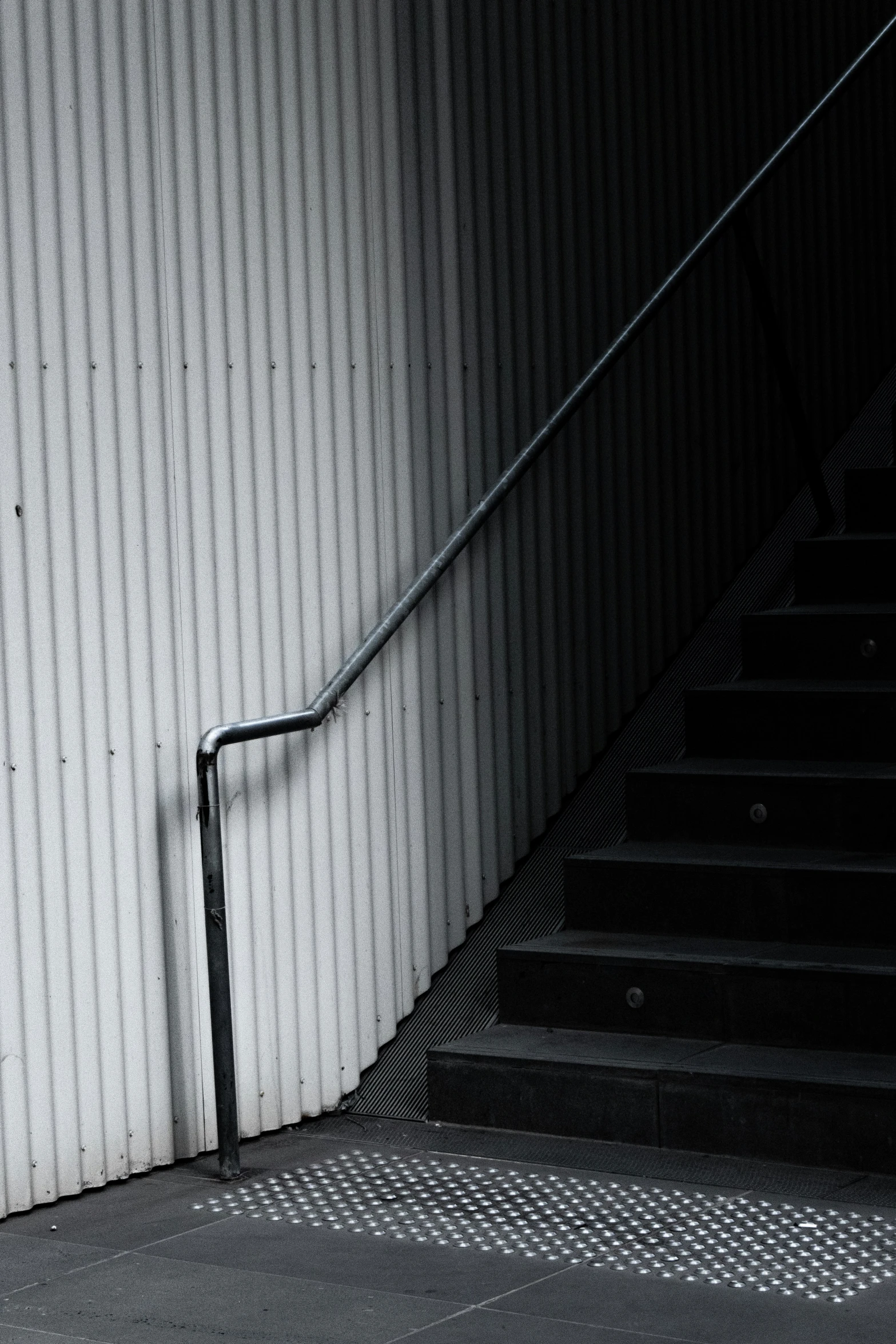 a man is standing with his hand on the handlebars near some stairs