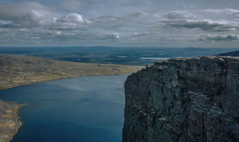 a large mountain cliff in the middle of a lake