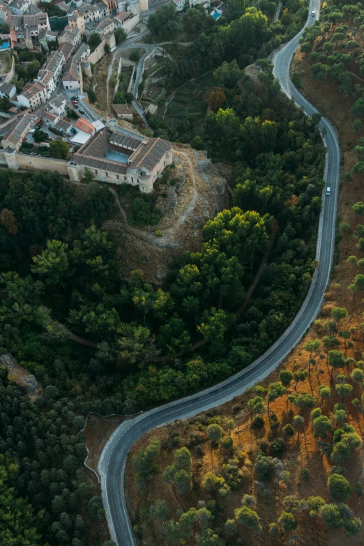 a scenic view of a winding road near some houses