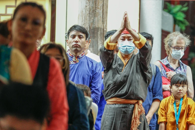 several people standing together in front of a crowd with masks on