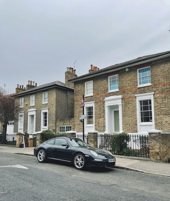 a black porsche parked on the side of a street