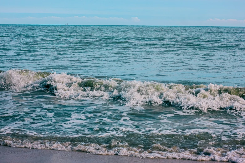 a beach with waves crashing on the sand