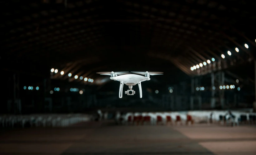 a large white camera flies in the air above a dance floor