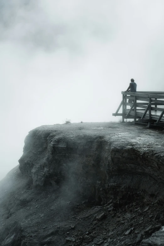 a man standing on top of a wooden bridge