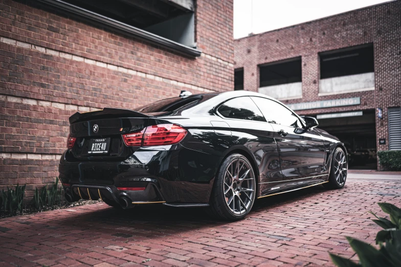 an all black sedan parked on a brick driveway