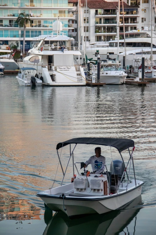 a man on a motor boat in a marina